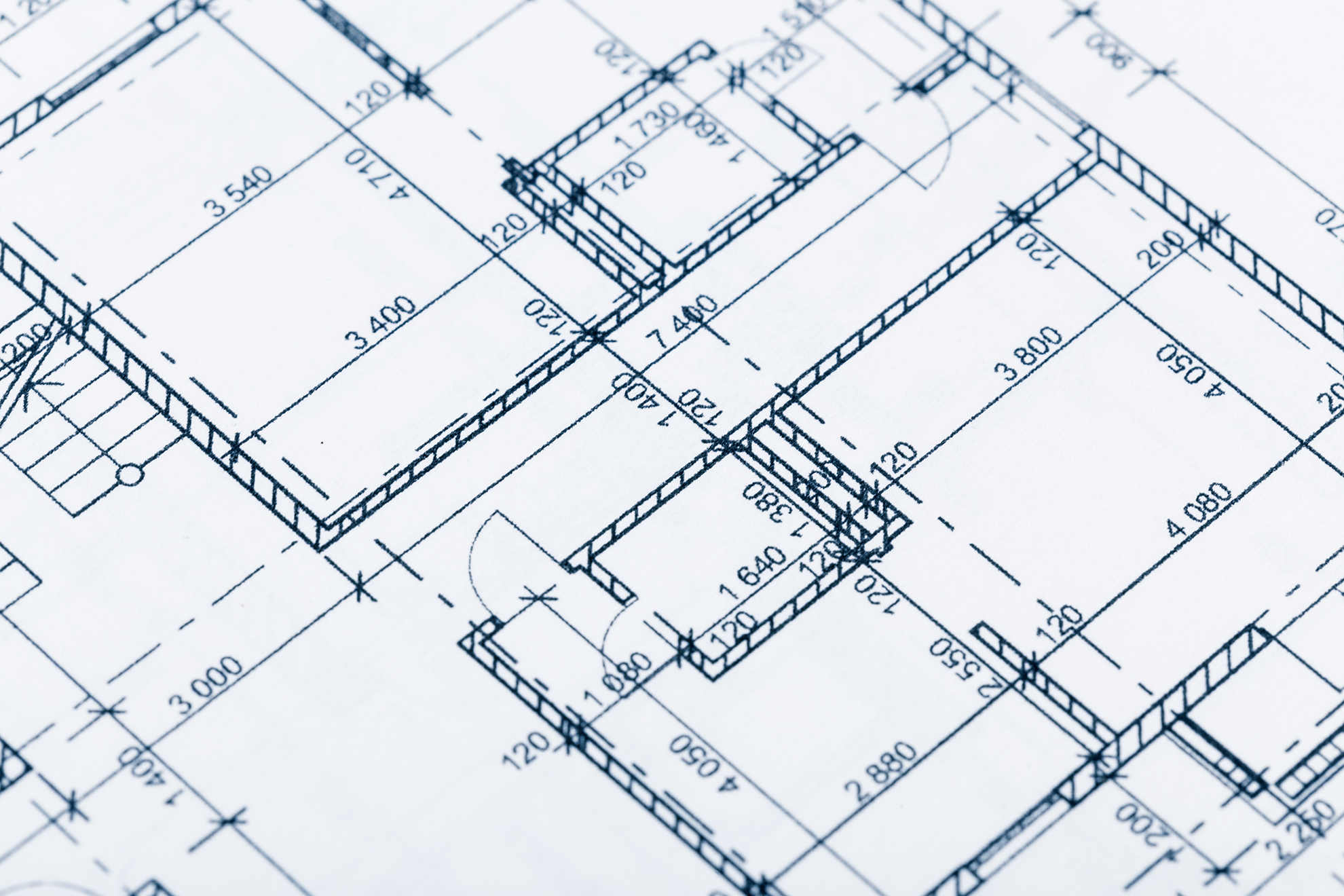 Close-up view of architectural blueprints showing detailed floor plan with labeled measurements and room layouts, highlighting professional Blueprint Design Services.